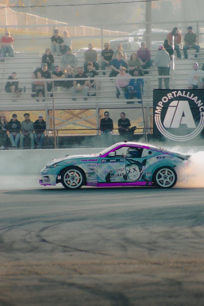 menu-14 Nissan 370Z car drifting at an exciting automotive event with spectators.