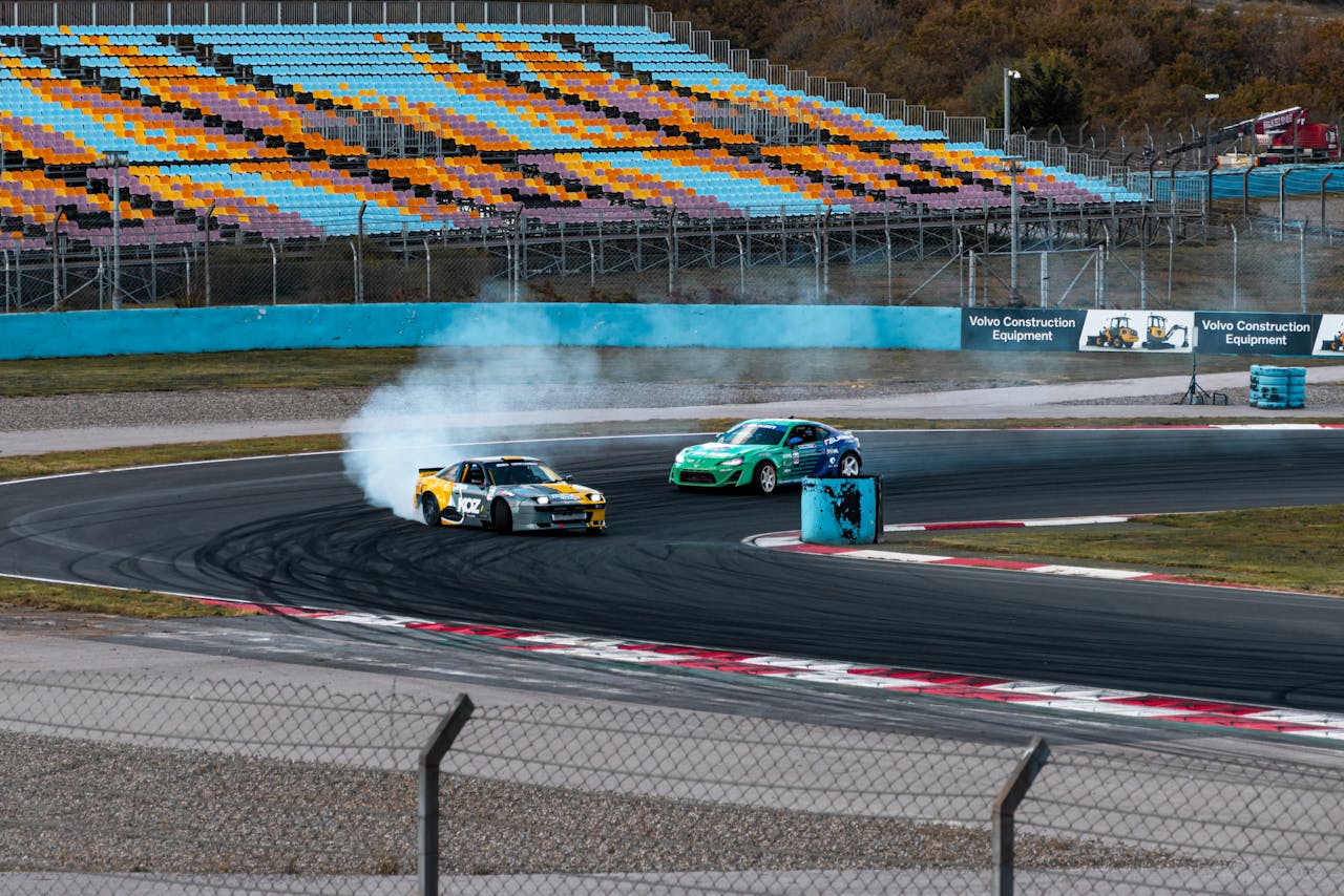 menu-10 Captivating shot of cars drifting on a race track with cloud of smoke trailing behind.
