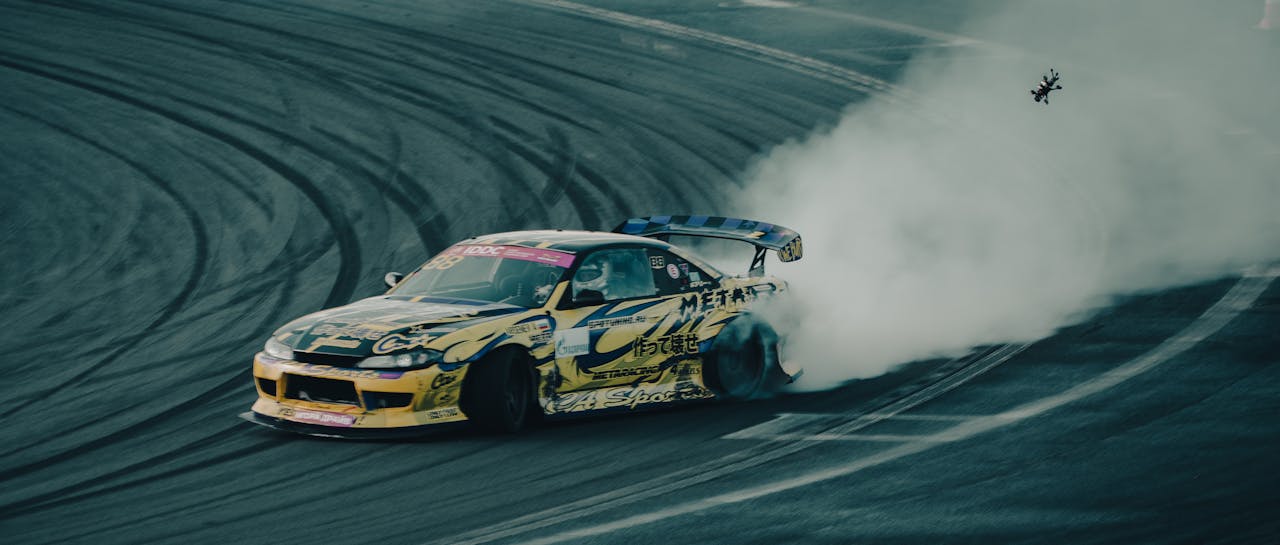 A dynamic drift car skids on the track, creating dramatic smoke trails.